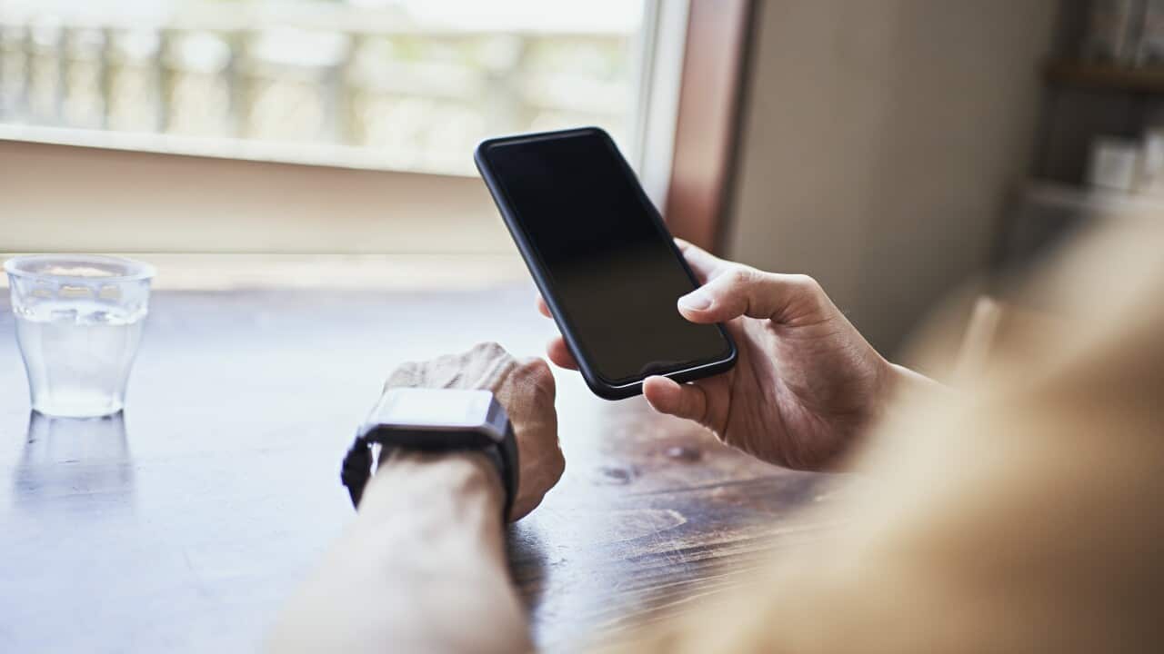 Man checking smartwatch and syncing smartwatch