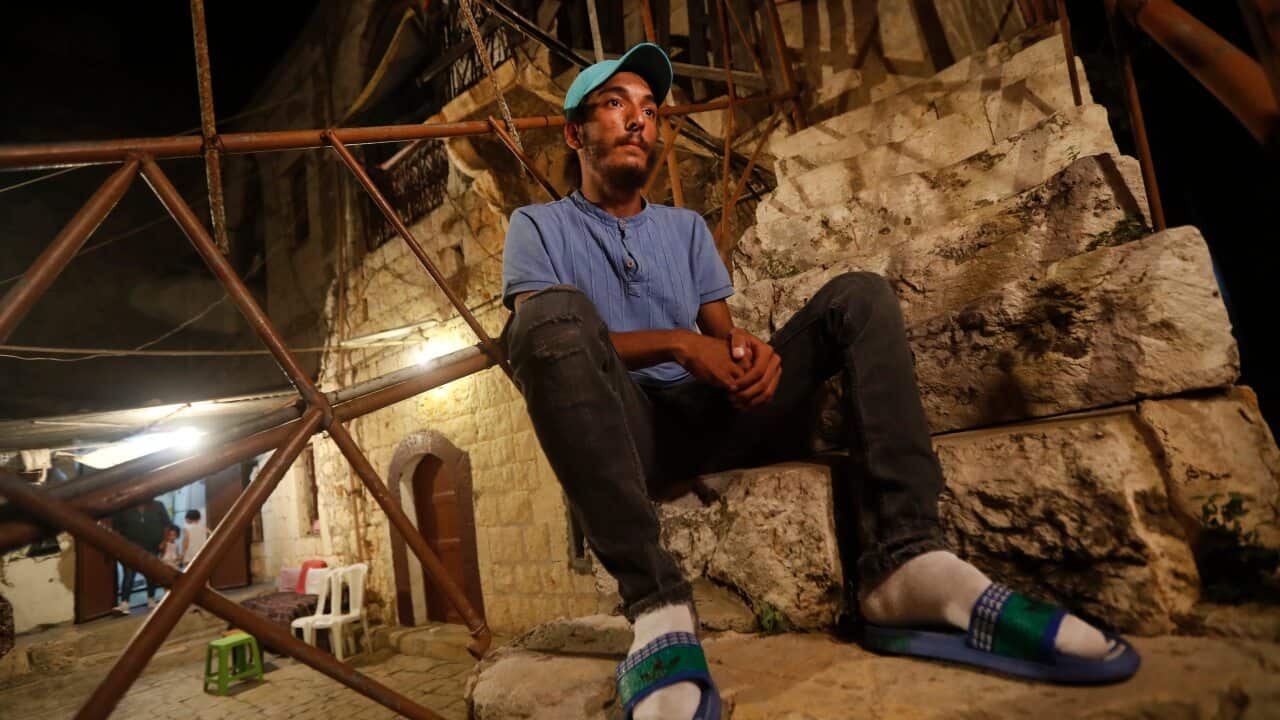 Mohammed Sufian sits outside his house in Tripoli after being rescued at sea while trying to migrate with his family to Cyprus. His son died on the journey.