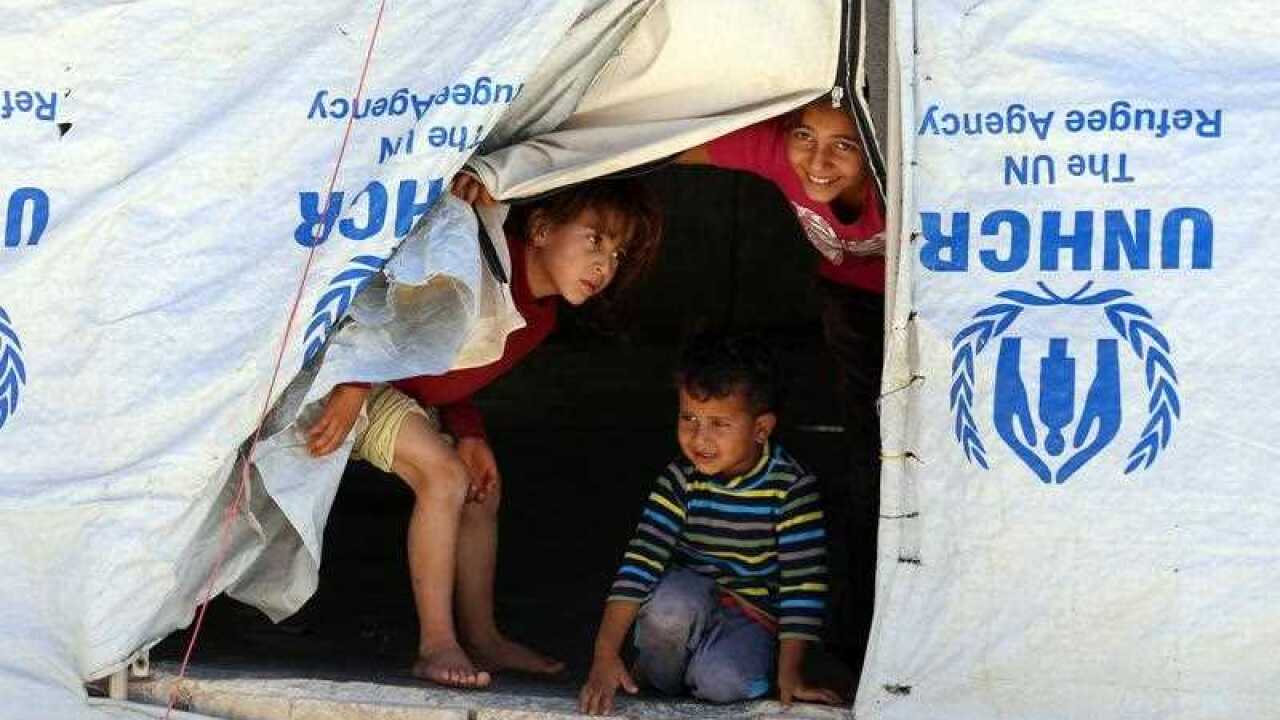 Syrian refugee children look from their tent during a visit by UN humanitarian chief Stephen O'Brien to the Zaatari Refugee Camp, near Mafraq, Jordan