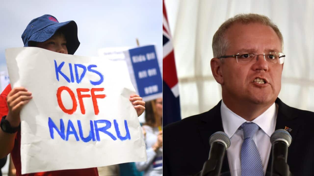 Protesters hold up signs during a rally demanding the resettlement of kids held on Nauru outside Parliament House in Canberra, Tuesday, November 27, 2018.