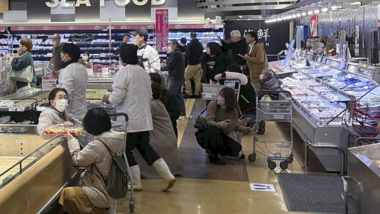 Customers crouch following an earthquake at a supermarket in Toyama, Japan (AAP)