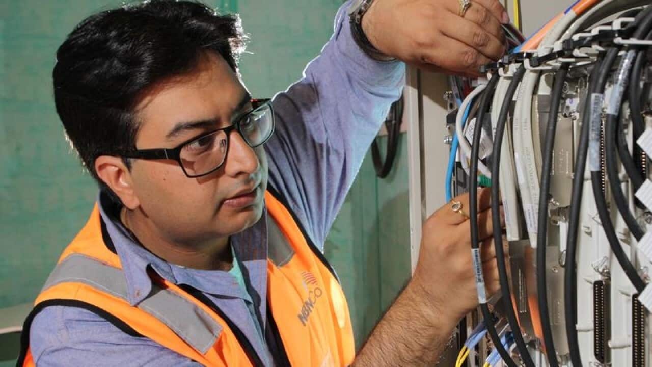 A technician connects an apartment block to the NBN