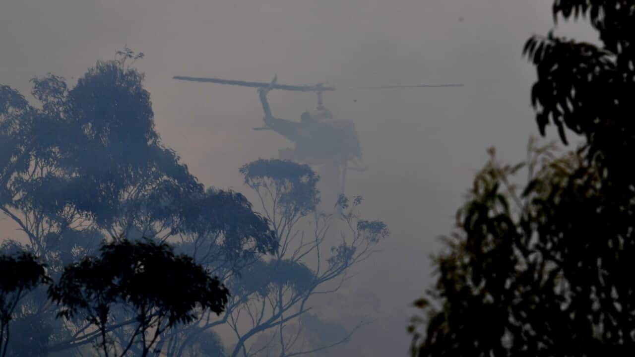 A water bombing helicopter helps to contain the Gospers Mountain Fire (AAP).