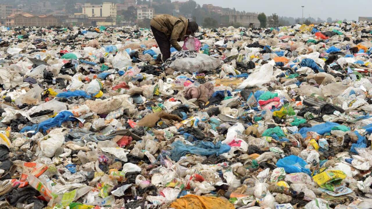 A man searches through waste at the Ngong town dumping site in Kenya, 30 kilometres southwest of Nairobi, on August 24, 2017.