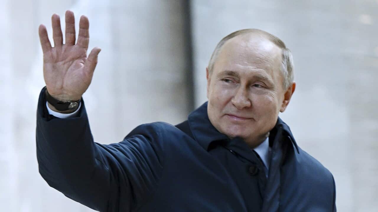 Russian President Vladimir Putin gestures as he leaves after visits the construction site of the National Space Agency in Moscow.