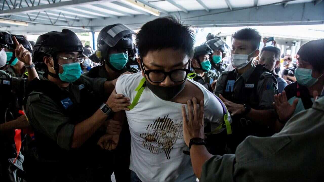 TOPSHOT - Police officers arrest a pro-democracy demonstrator (C) during a pro-democracy protest calling for the city's independence in Hong Kong on May 10, 2020. (Photo by ISAAC LAWRENCE / AFP) (Photo by ISAAC LAWRENCE/AFP via Getty Images)