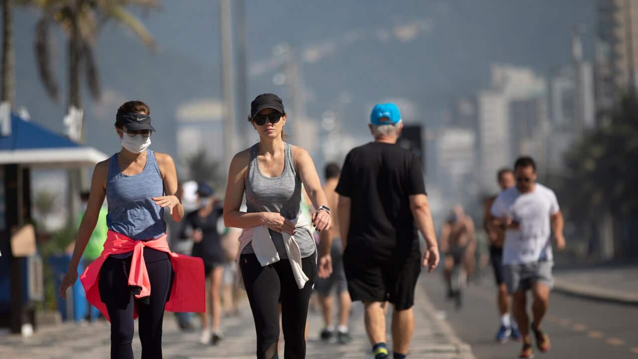 People exercise along the seashore at Ipanema beach in Rio de Janeiro after lockdown rules were relaxed