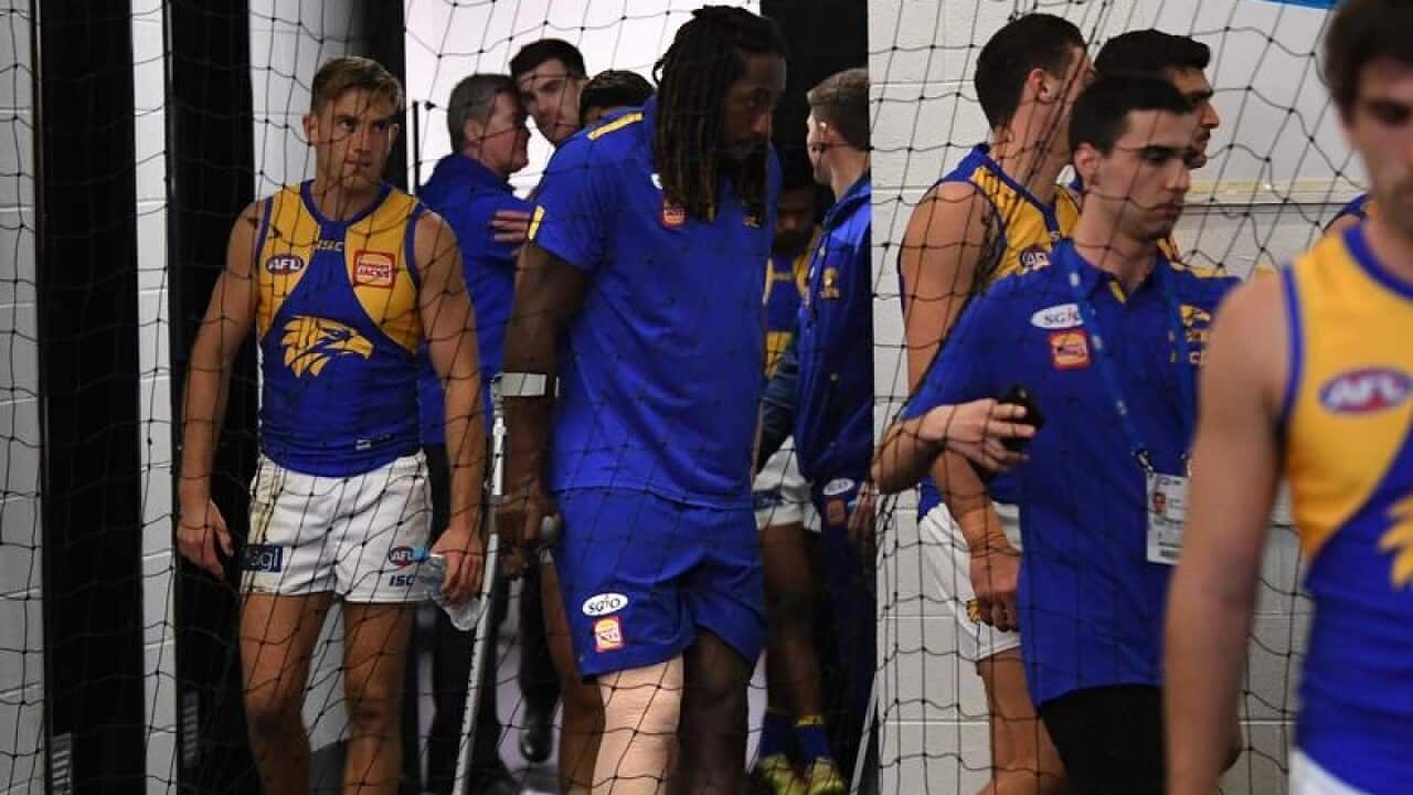 Nic Naitanui is seen using crutches in the Eagles locker room.