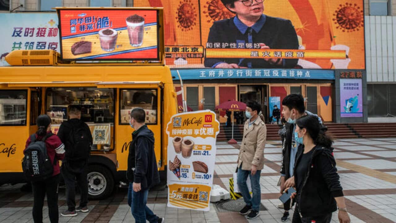 在北京一家新冠疫苗接种中心外,麦当劳的冰淇淋车为接种者推出“买一赠一”的促销活动。