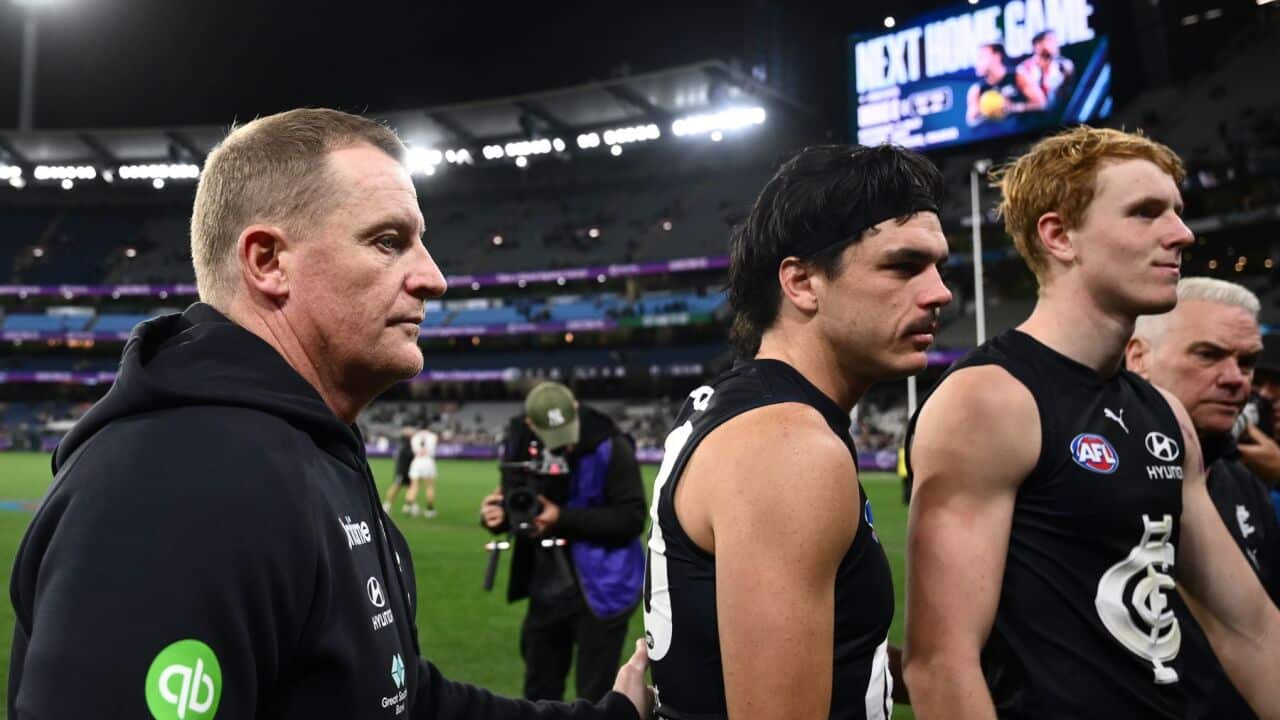 Carlton Blues head coach Michael Voss (left) and Elijah Hollands of Carlton (centre) leave the field following the AFL Round 6 match