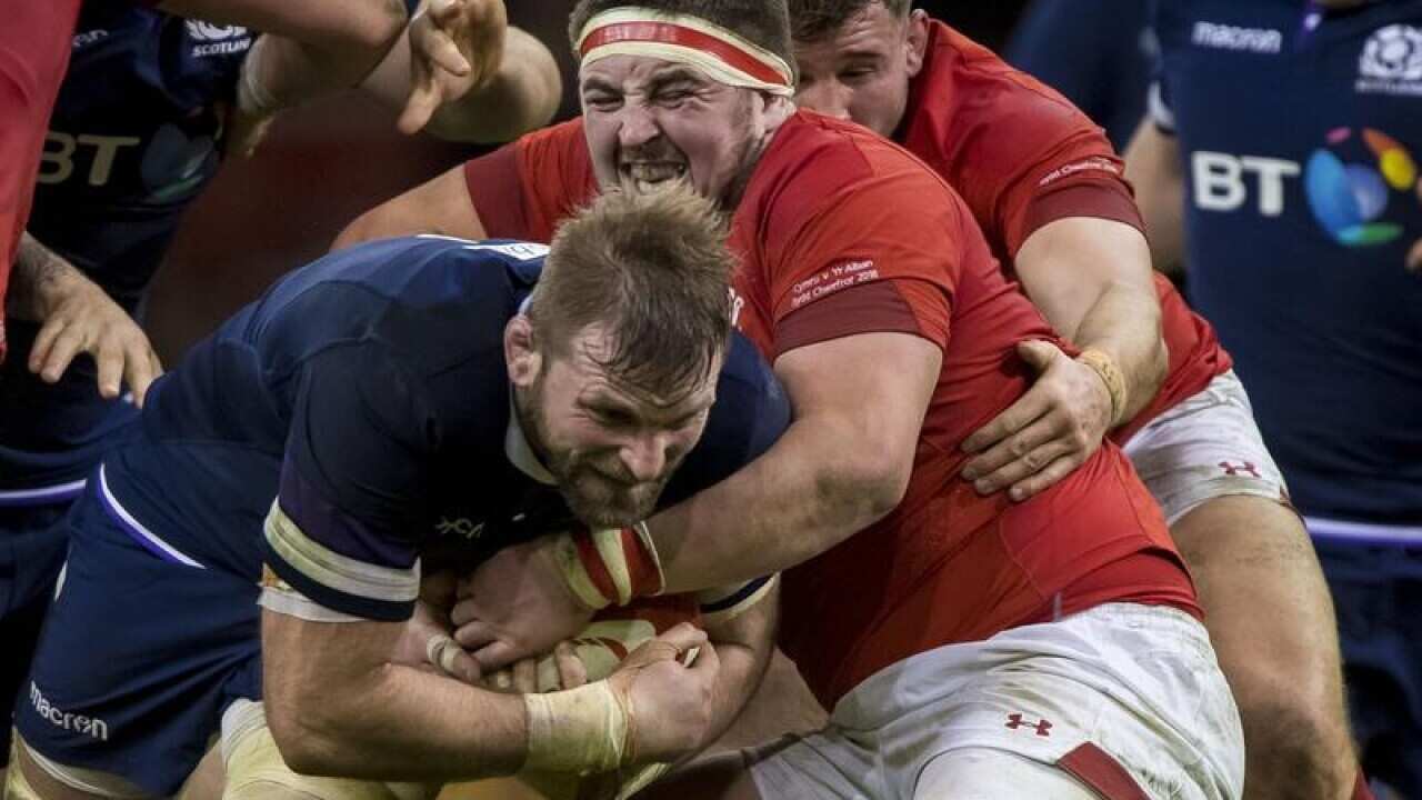 Wyn Jones of Wales tackles Scotland's John Barclay.