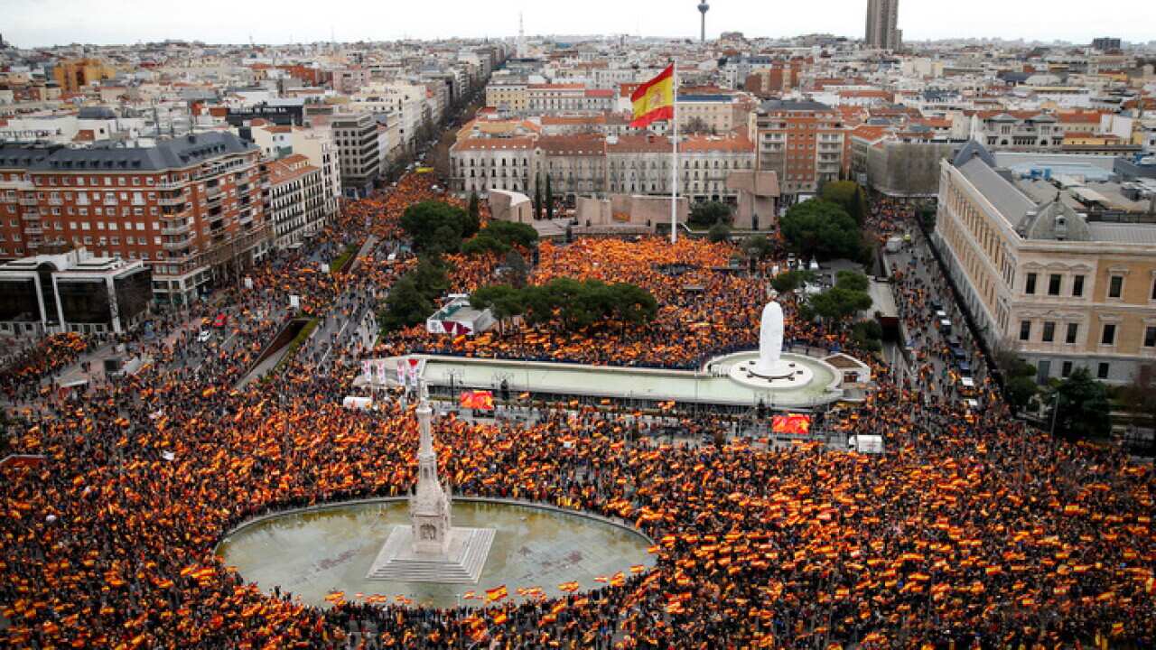 Thousands of demonstrators hold Spanish flags during a protest in Madrid