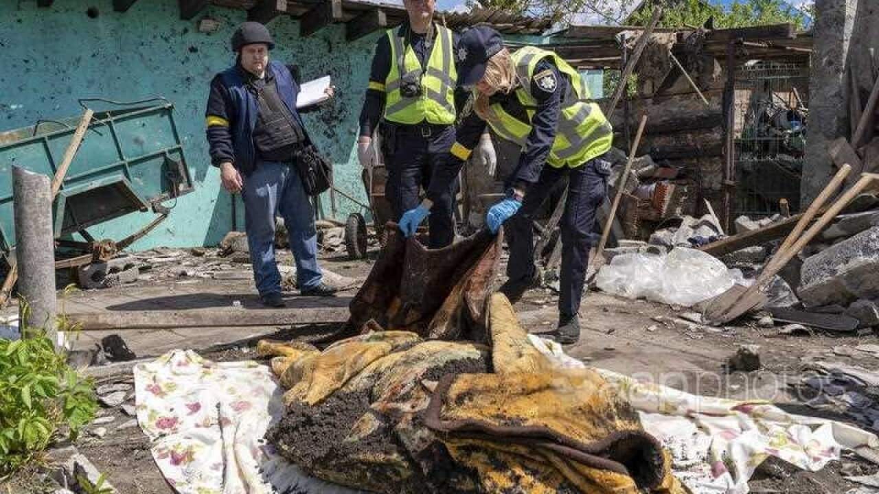 Ukrainian police inspect the body of a man reportedly killed in the recent shelling of the city of Kharkiv by Russian forces following its exhumation, Kharkiv, Ukraine.