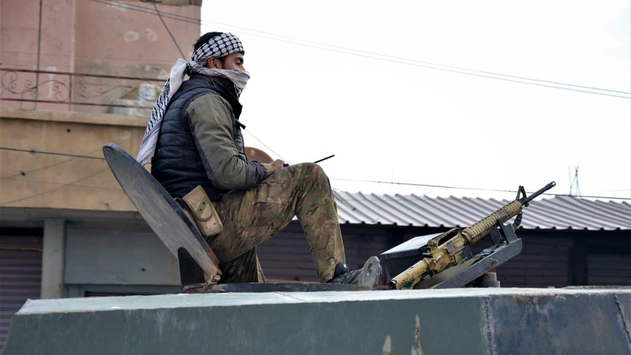 A Fighter of the Syrian democratic forces (SDF) takes up position during a military search operation in Hasaka,
