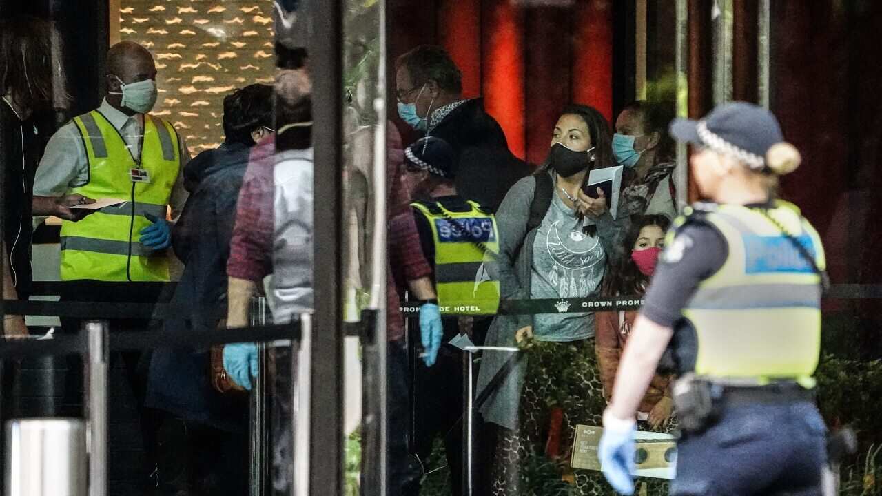 Recently arrived overseas travellers get off their bus and wait to check in at the Crown Promenade Hotel in Melbourne, Sunday, 29 March, 2020.