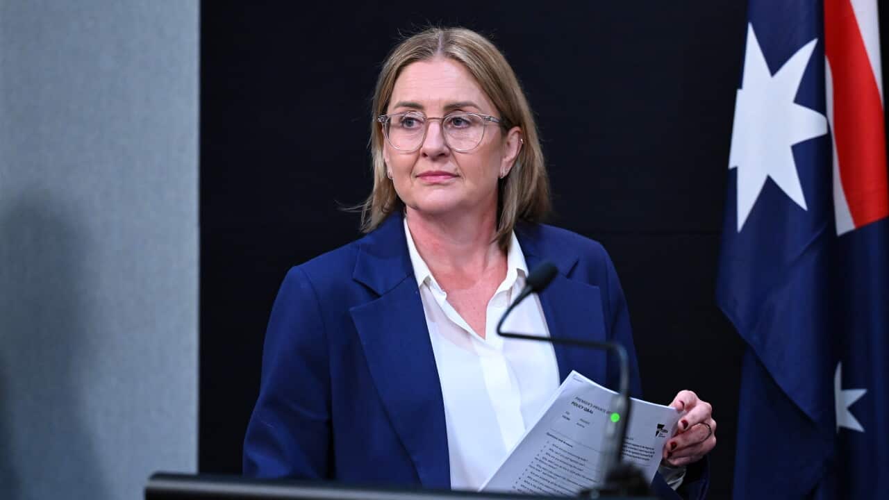 A middle-aged white woman standing before a lectern.