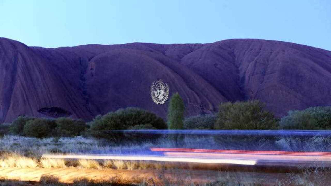 The United Nations' crest is projected onto Australia's iconic red rock, Uluru, also known as Ayres Rock, for the organisation's 70th anniversary
