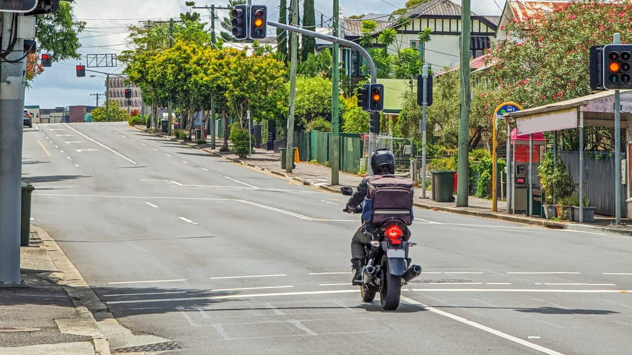 Motorcycle rider, empty suburban main road