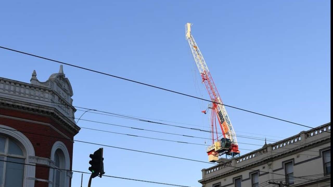 Emergency workers are taking down a damaged crane in Richmond.