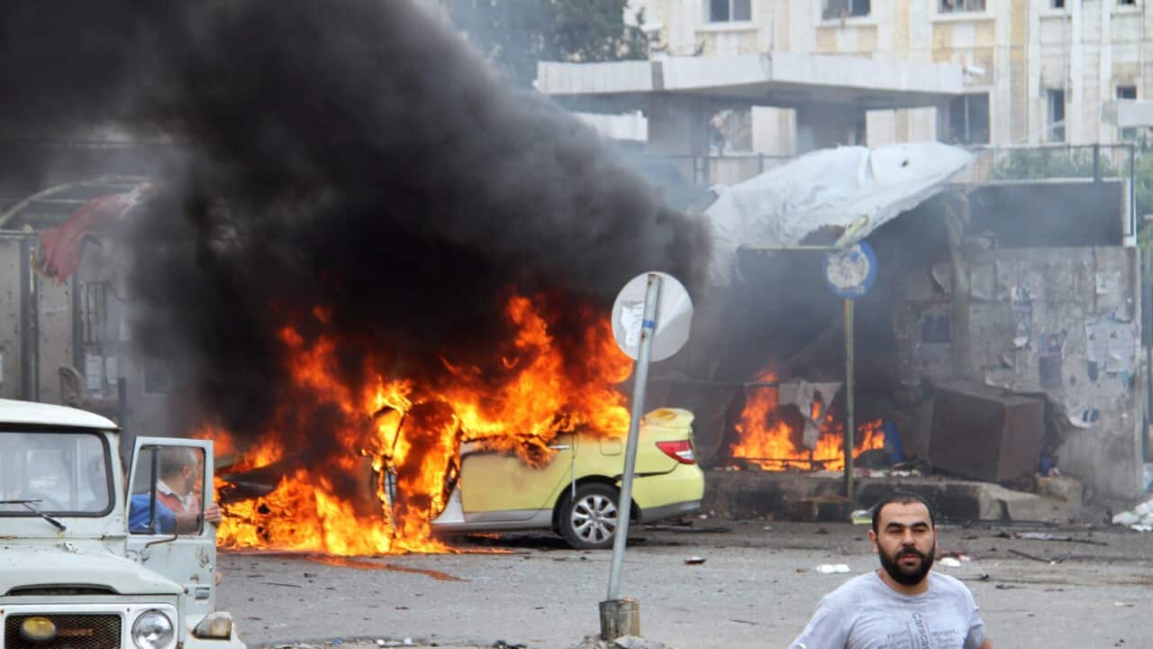 A photograph released by the official Syrian Arab News Agency (SANA) shows flames rising following a bombing at a bus station in Syria