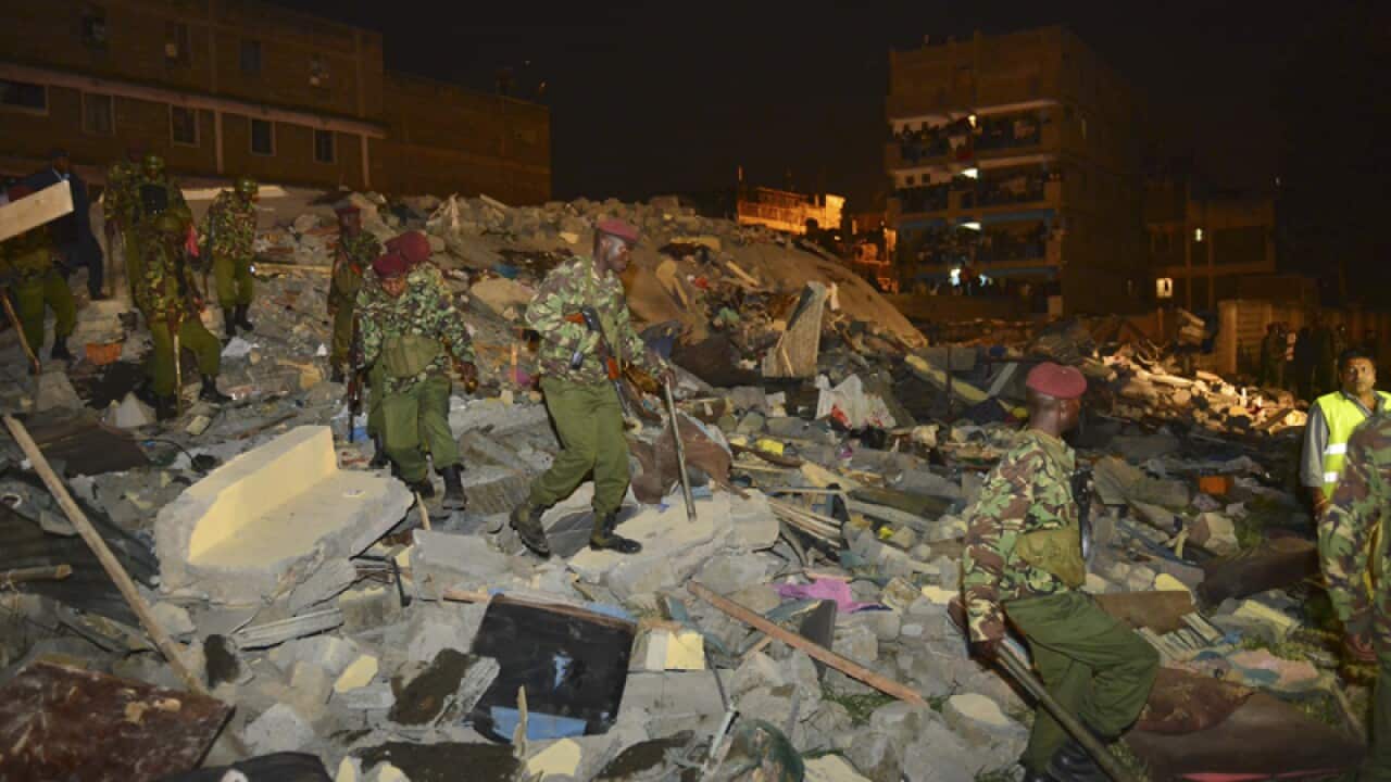 Kenyan military soldiers search for survivors of a building collapse