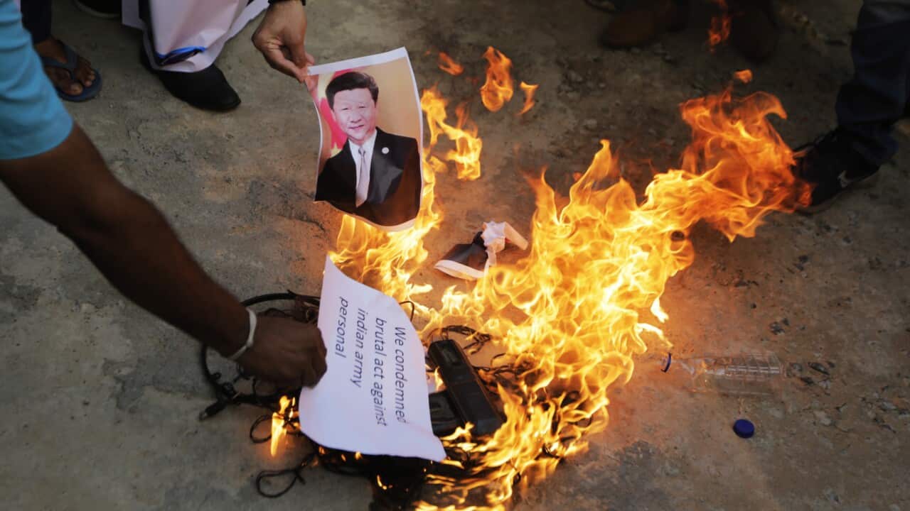 An Indian man burn a photograph of Chinese president Xi Jinping during a protest against China in Ahmedabad, India, Tuesday, June 16, 2020.