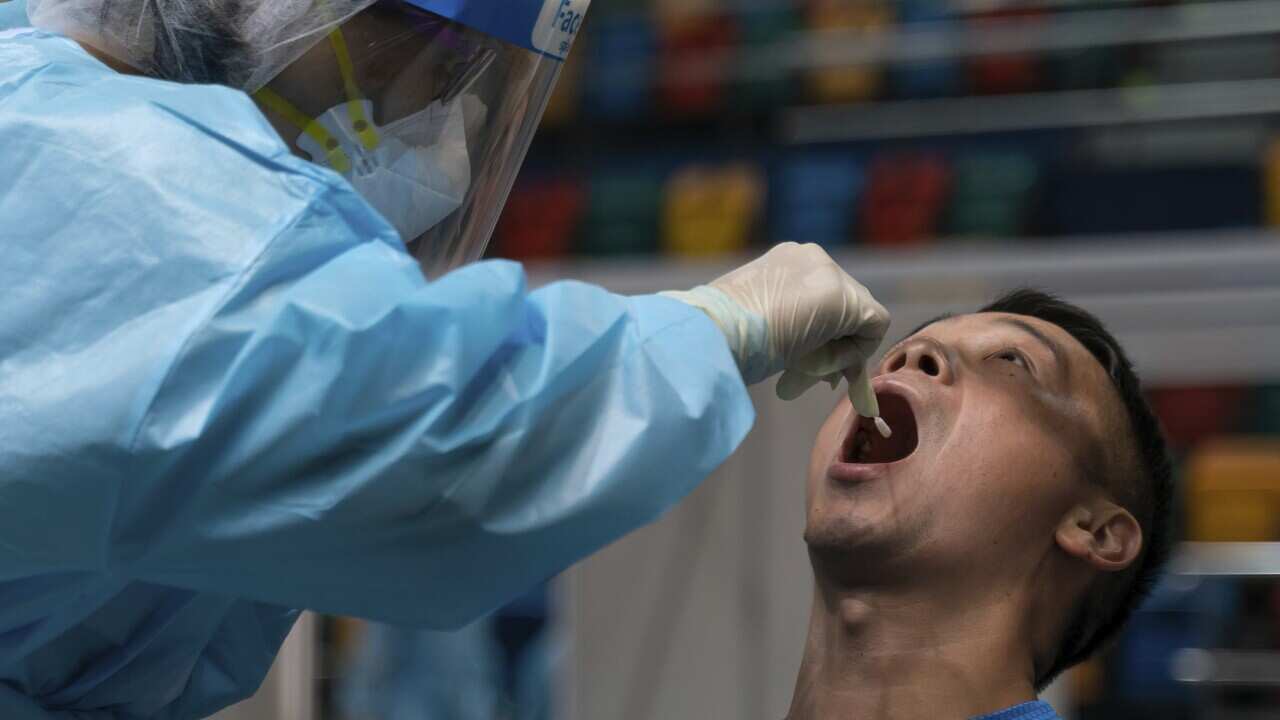 A swab sample is collected from a man at a makeshift testing site at Queen Elizabeth Stadium in Hong Kong on 1 September.