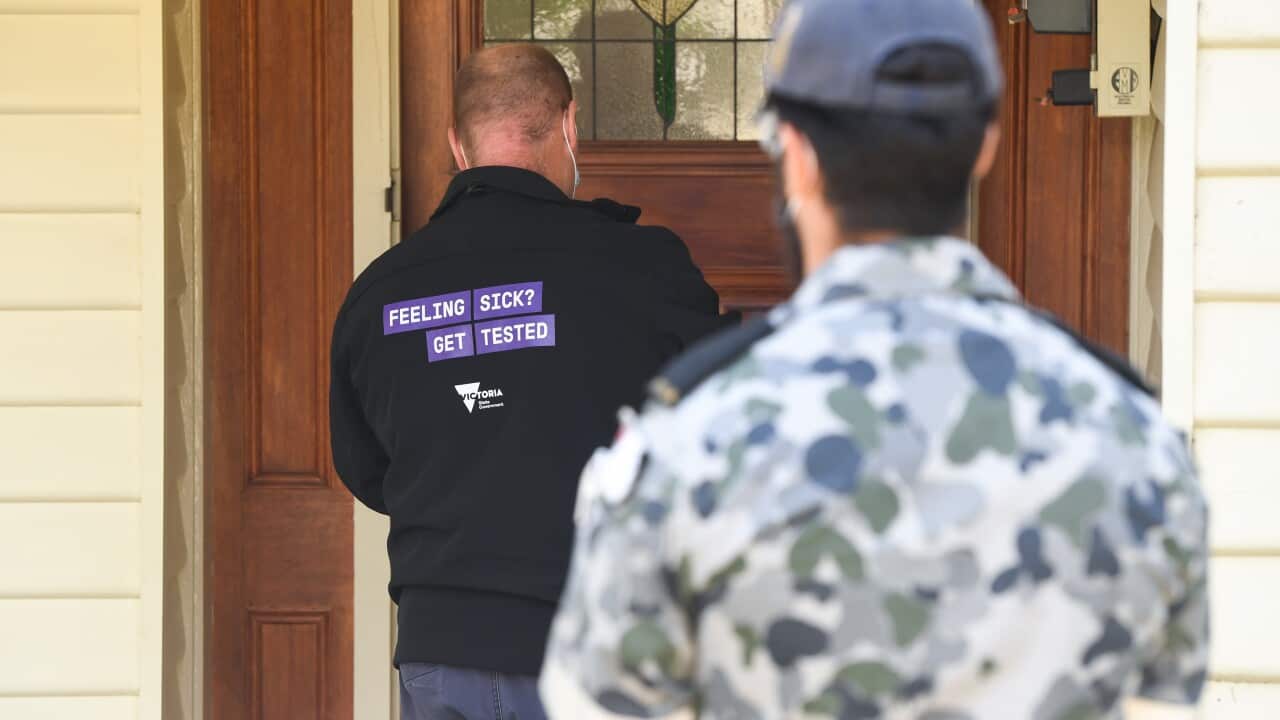 A government health official is seen during a door knock welfare check in Brunswick West, Melbourne.