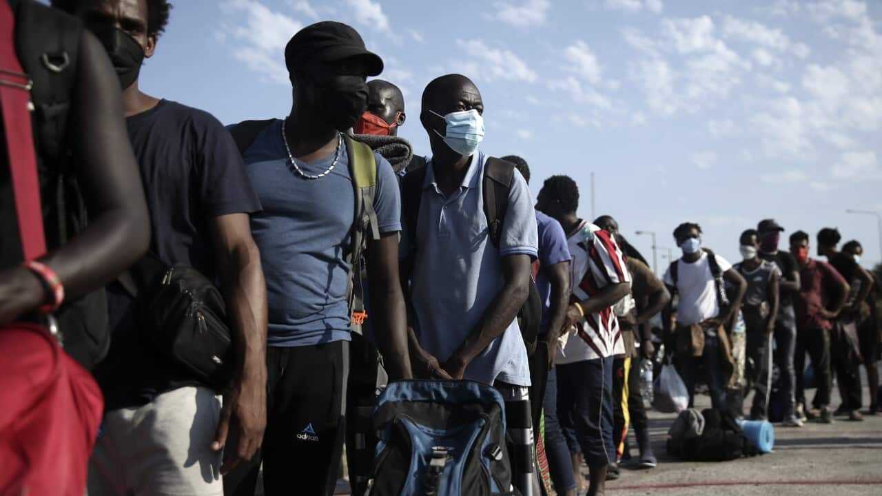 Migrants wait in a queue to enter a temporary camp near Mytilene town, on the northeastern island of Lesbos, Greece, Saturday, 12 September, 2020.