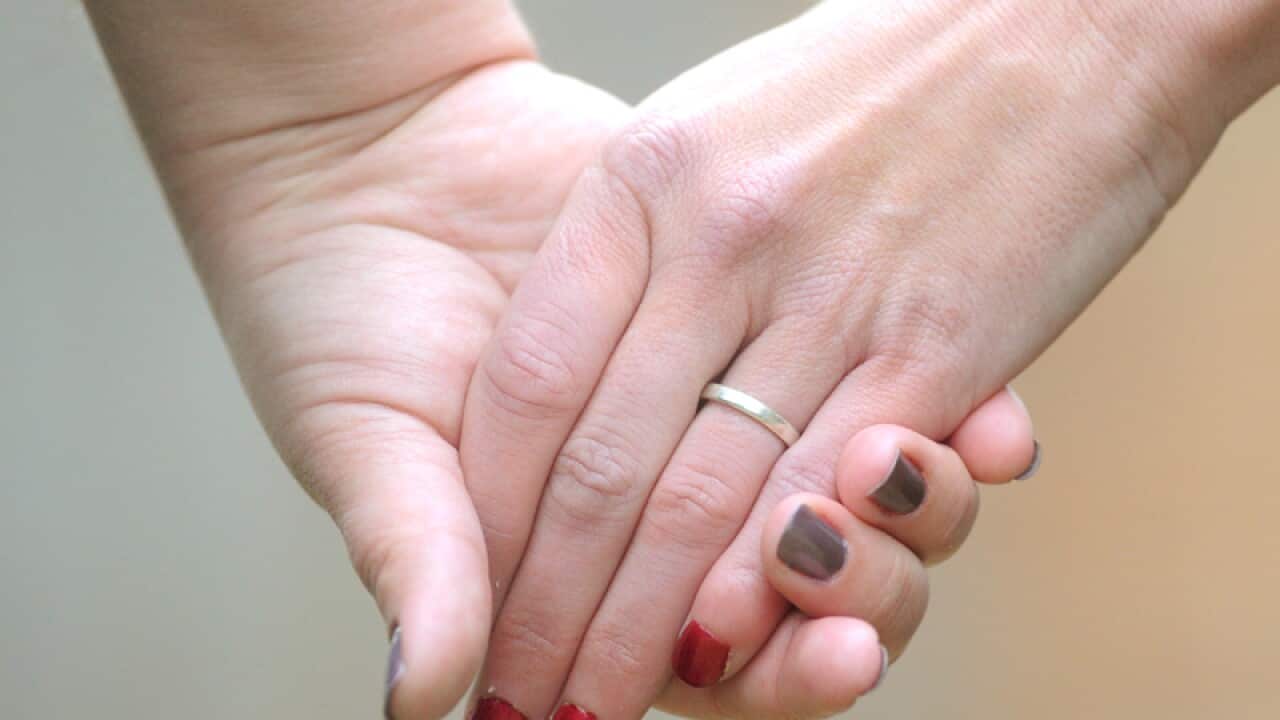 Women hold hands