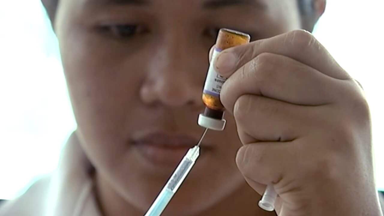 A New Zealand health official prepares a measles vaccination at a clinic in Apia, Samoa.