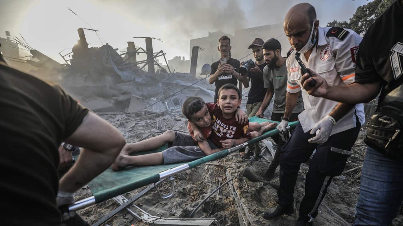 Palestinians carry wounded brothers on a stretcher after recovering them from the rubble of a destroyed area following Israeli air strikes in Gaza City.