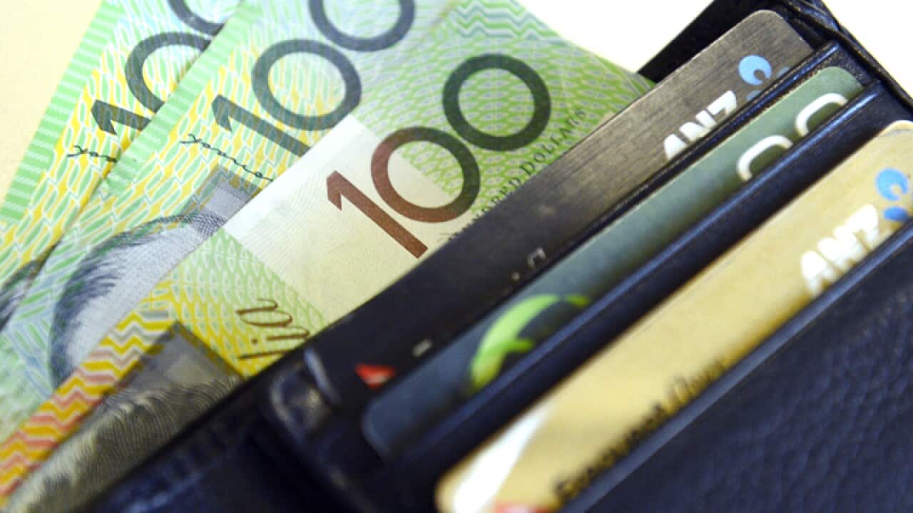 $100 Australian dollar notes pop out of a wallet in Brisbane