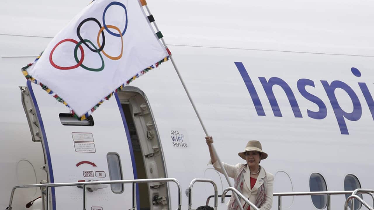 Tokyo Governor Yuriko Koike carries the Olympic flag