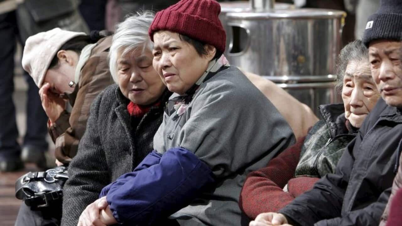 epa00633658 Elderly people warming themselves up in the afternoon sun in Shanghai, China on Wednesday, 08 February 2006. China recently said its income gap between rich and poor has widened to an alarming and unreasonable level. EPA/Qilai Shen