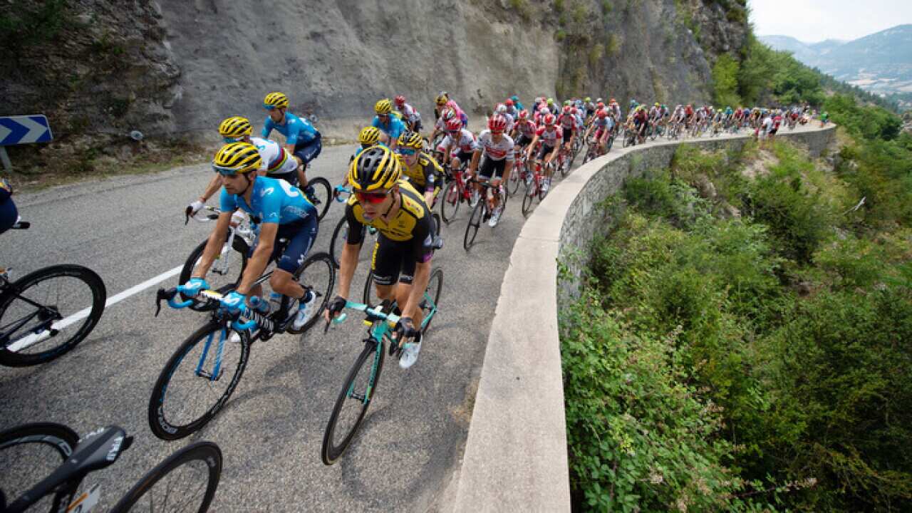 The peloton including Tony Martin for Jumbo Visma ride over the first climb of the day - the Cote de La Rochette du Buis in the Tour de France 2019 Stage 17 - Pont - Du - Gard to Gap.