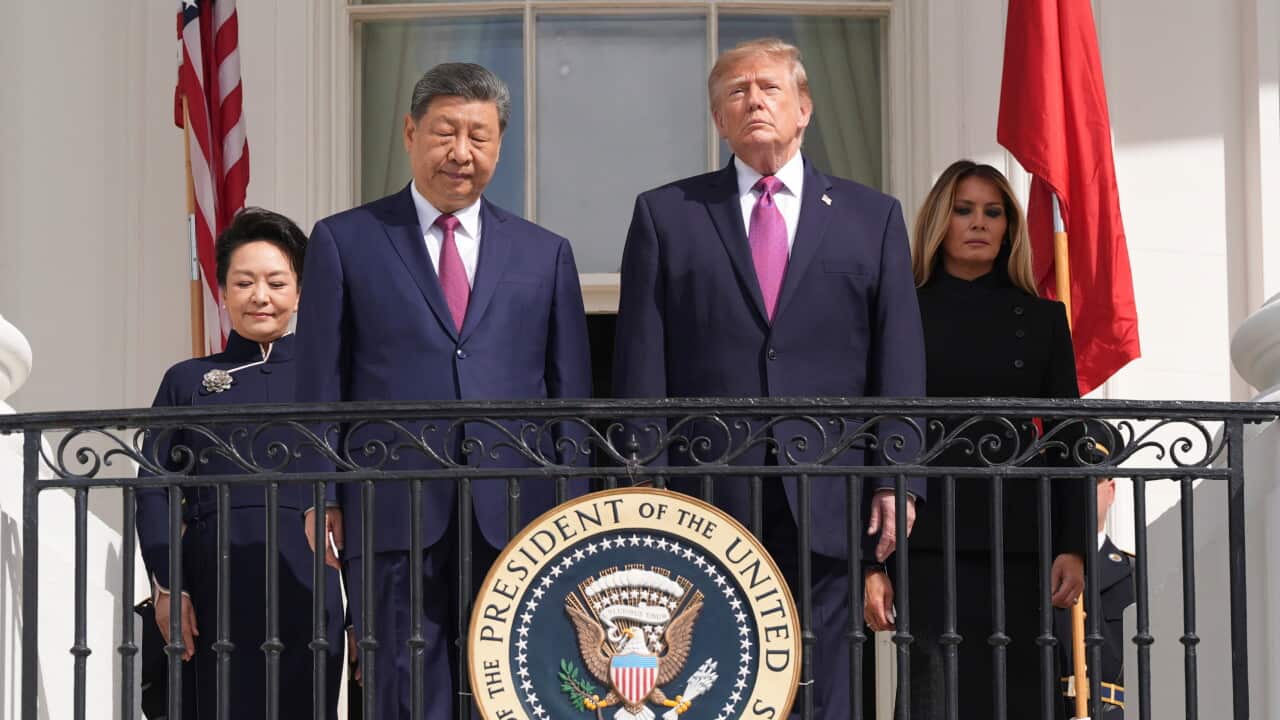 Four people stand on a White House balcony behind the Seal of the President of the United States, flanked by US and Chinese flags.