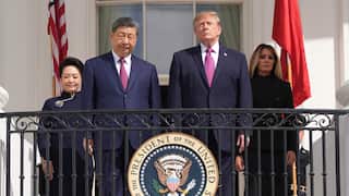 Four people stand on a White House balcony behind the Seal of the President of the United States, flanked by US and Chinese flags.