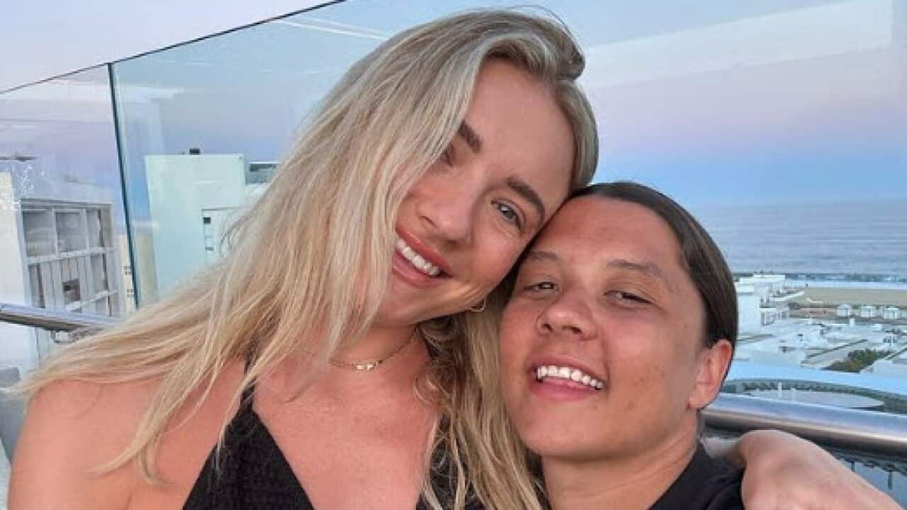 Matildas star Sam Kerr posing with a blonde woman sitting on her lap