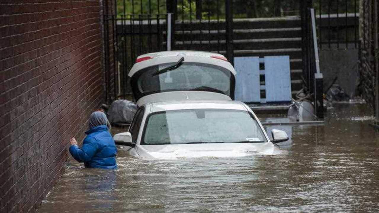 A boy wades towards a flooded alleyway in Pontypridd, South Wales, Britain, 16 February 2020.