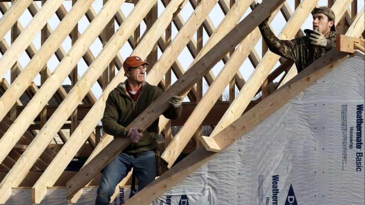 two men roofing a newly-built house
