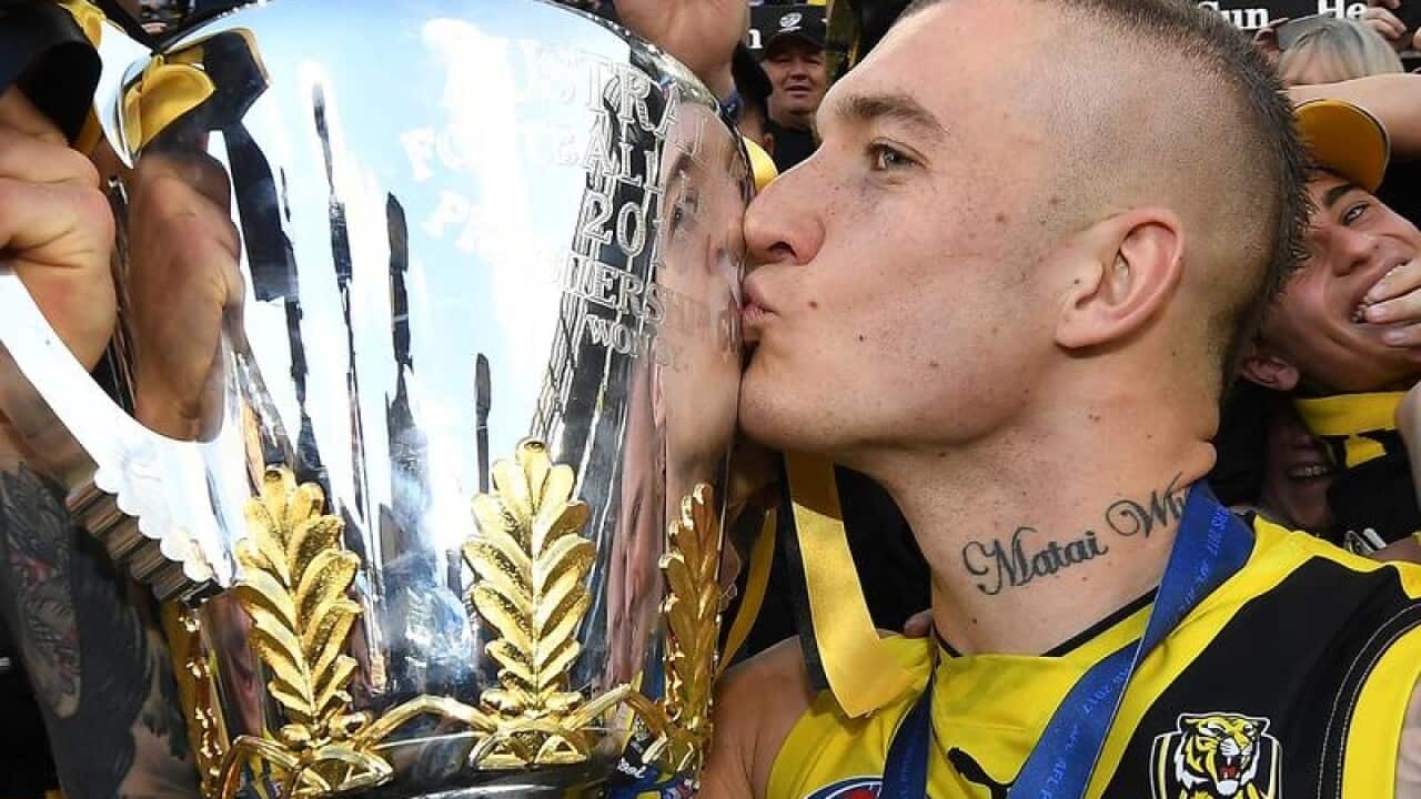 Richmond Tigers player Dustin Martin kisses the AFL Premiership trophy