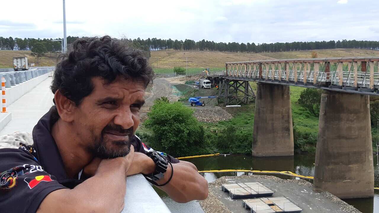Terrence Robinson from the Jana Ngalee Land Council looks out over the bridge as crews and machinery arrive for the demolition