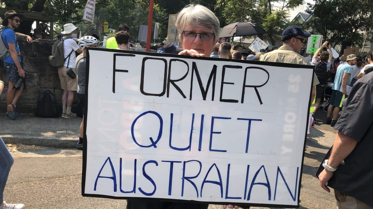A protester holds a sign reading "former quiet Australian"