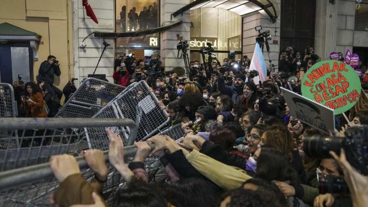 Demonstrators in Istanbul pull down a police security fence.