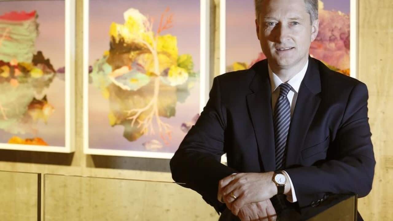 DuluxGroup MD Patrick Houlihan in front of paintings on wall