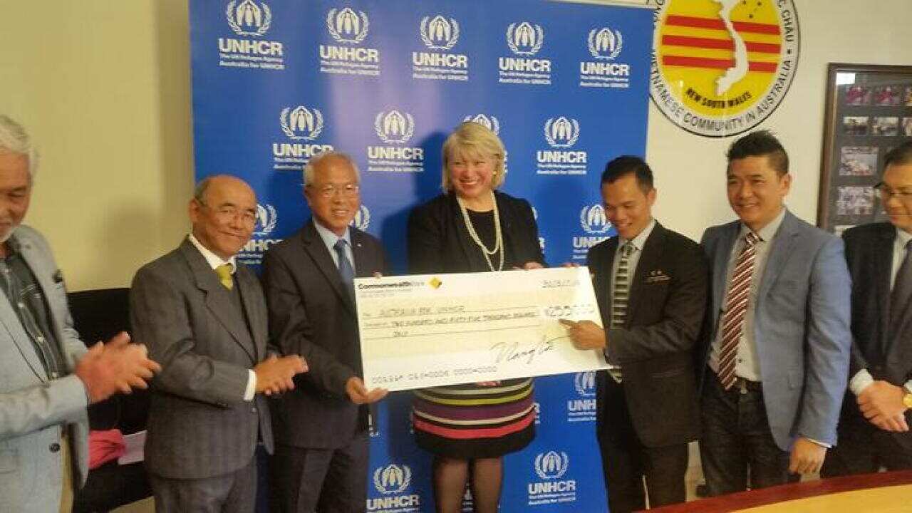 Vietnamese Community NSW members hand UNCHR National Directorm Naomi Steer, a cheque for $255,000 to assist all refugees