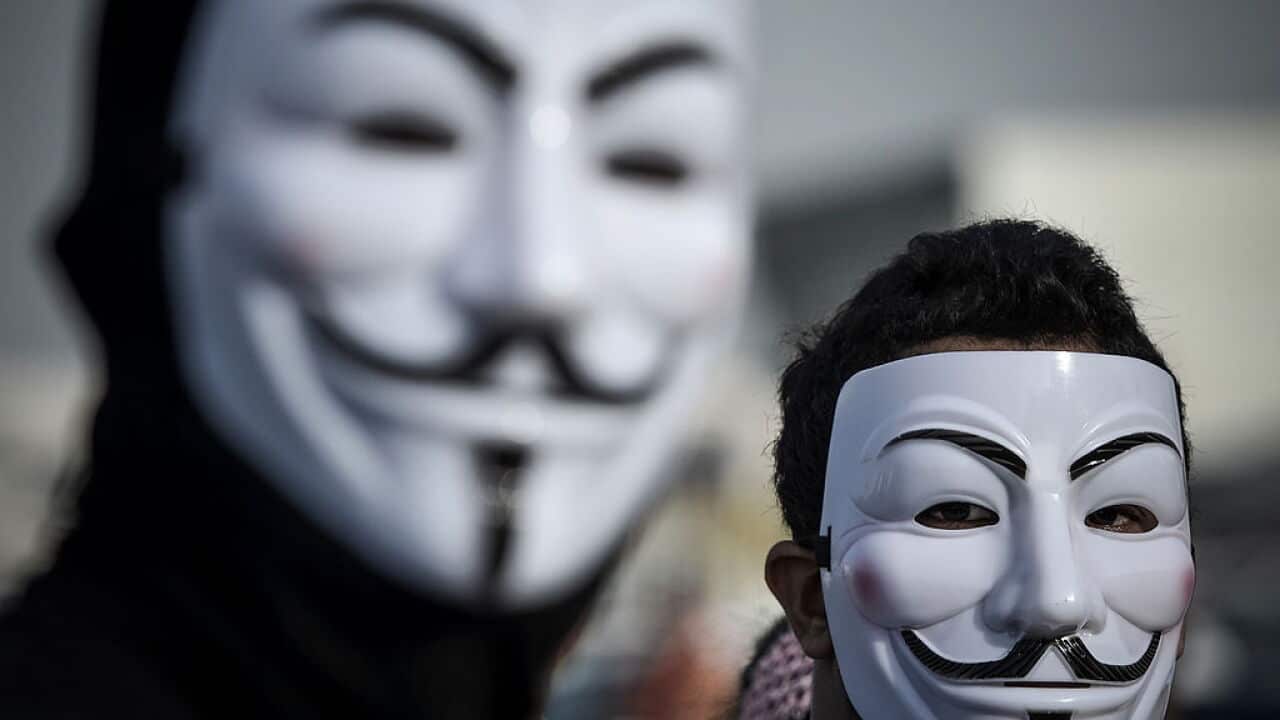 Protesters wearing Guy Fawkes masks used by the Anonymous movement