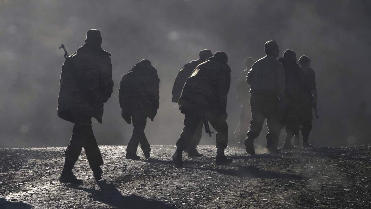 Armenian soldiers walk along the road near the border between Nagorno-Karabakh and Armenia, Sunday, Nov. 8, 2020.