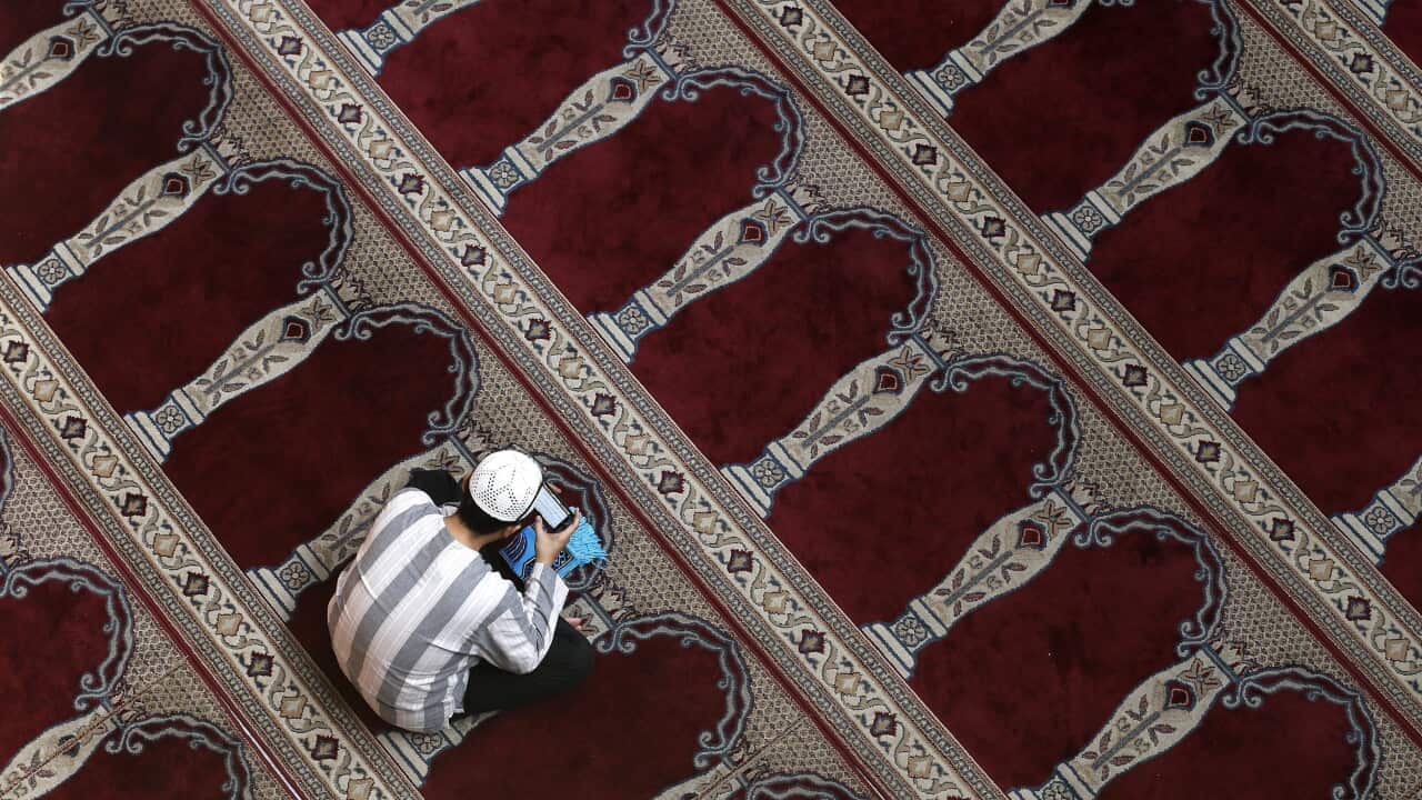 An Indonesian Muslim reads the Koran on his mobile phone